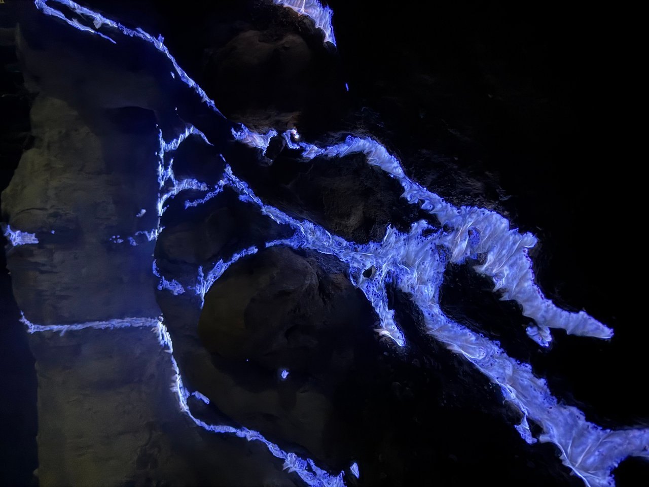 Blue flame spreading across the rock where liquid sulfur runs out of the vents